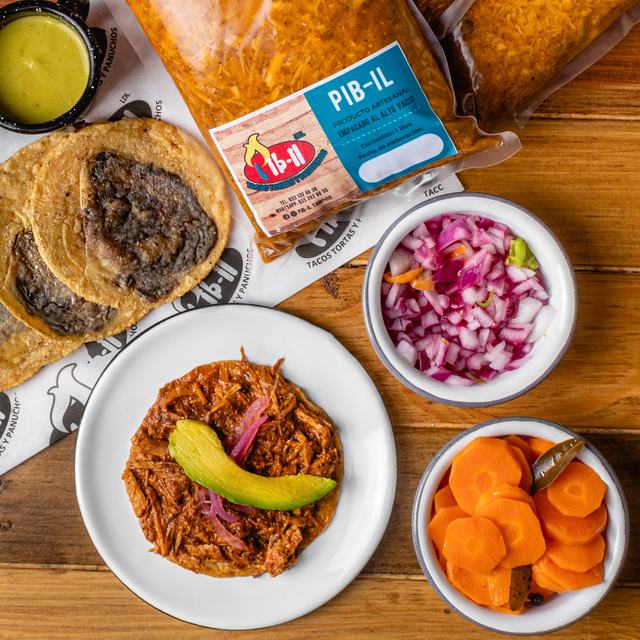 Cochinita pibil recién horneada con panuchos, cebolla morada y salsas en Pib-il Tampico